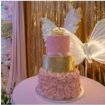 Three tier pink and gold butterfly cake on a styled cake table